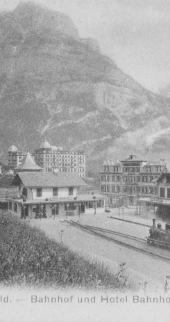 Historic Grindelwald train station and hotel in a serene mountain setting, evoking a nostalgic and peaceful ambiance for travel enthusiasts.