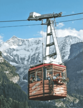 Red cable car ascending against a backdrop of snowy Alps, offering an adventurous yet serene travel experience.