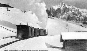 Vintage train chugging through a snowy landscape with a mountain backdrop, capturing a serene and nostalgic journey in winter tourism.