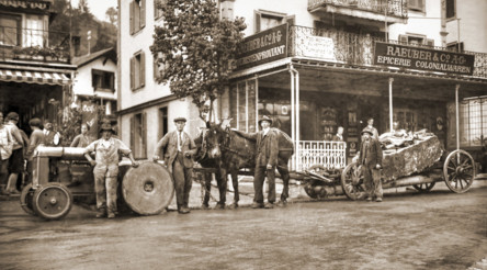 Sepia-toned historical street scene with horse-drawn carts and early 20th-century urban setting, evoking a nostalgic and bustling marketplace atmosphere.