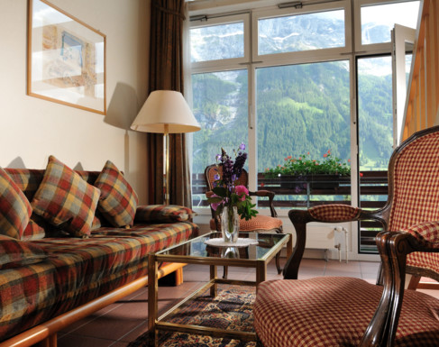 Cozy living room with plaid sofas and mountain views, offering a warm, inviting atmosphere for vacation property rentals.