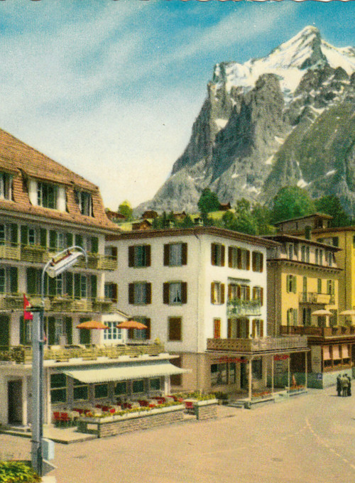 Quaint Alpine village with colorful buildings and snow-capped mountain backdrop, evoking a serene, picturesque setting ideal for tourism.