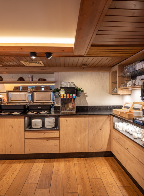 Cozy café corner with warm wooden décor and modern coffee machines, presenting a welcoming ambiance for coffee lovers.