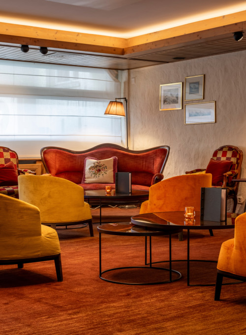 Warm-hued vintage lounge with plush yellow and red seating, inviting a cozy, nostalgic atmosphere perfect for social venues.