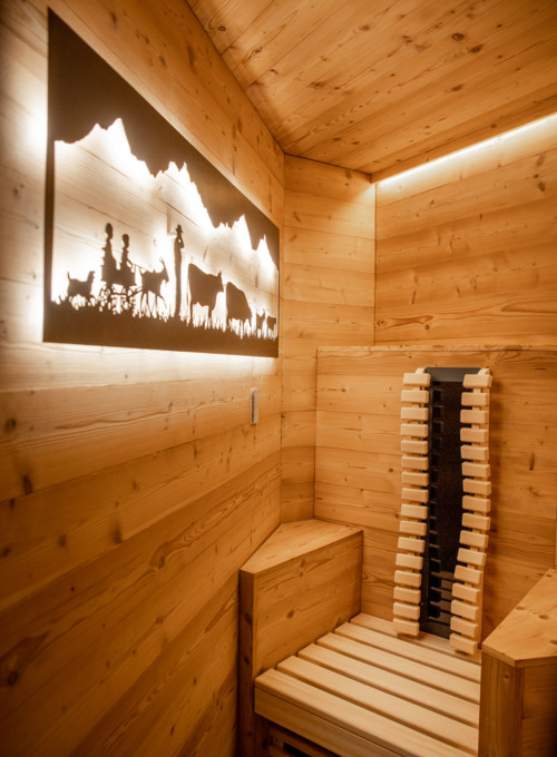 Warm wooden sauna with rustic backlight silhouettes of a pastoral scene, exuding tranquility for wellness enthusiasts.