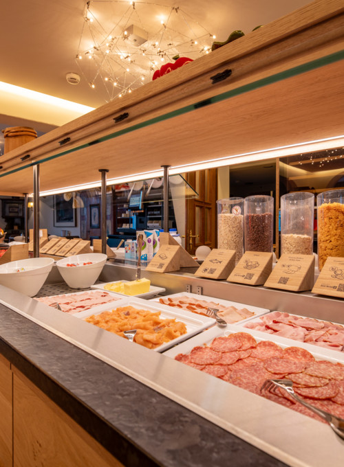 Cozy breakfast buffet setup with warm lighting and an array of fresh foods, inviting hospitality and culinary exploration.