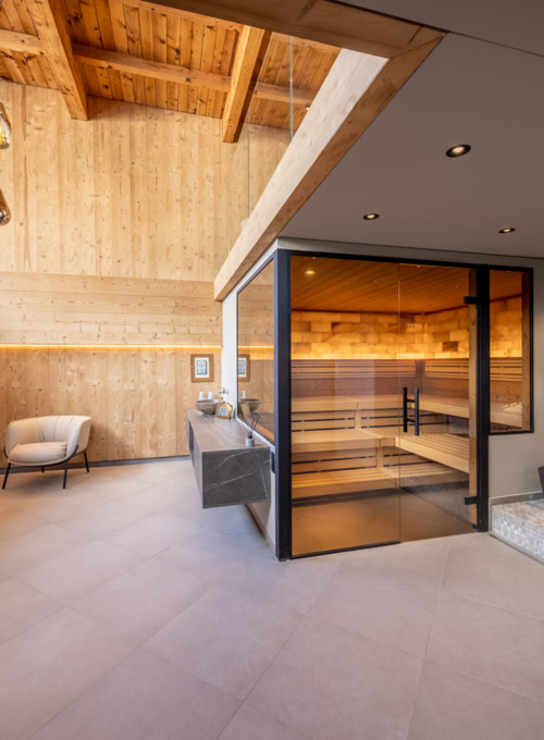 Spacious spa with warm wooden walls and contemporary furnishings, creating a serene escape for wellness-focused individuals.