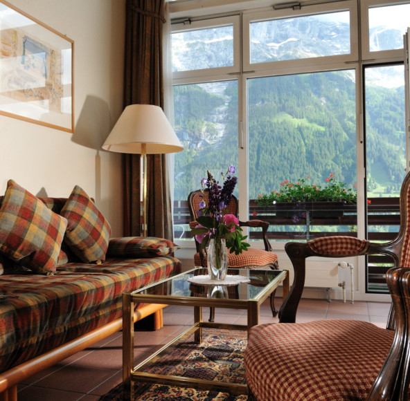 Cozy living room with plaid sofas and mountain views, offering a warm, inviting atmosphere for vacation property rentals.