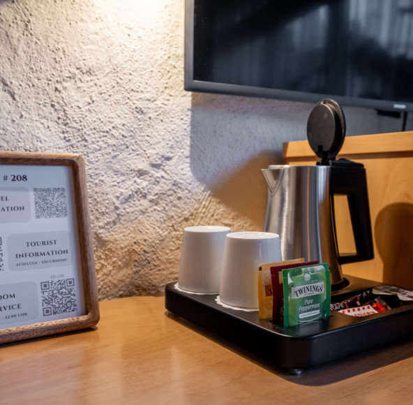 Cozy hotel hospitality corner with a wooden information frame and tea service setup, inviting and tailored for traveler convenience.