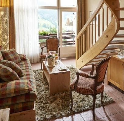 Cozy alpine-style living room with plaid sofa and wooden accents, exuding warmth and comfort, ideal for lodge or resort settings.