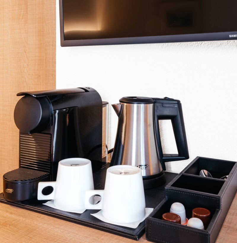 Sleek espresso machine and kettle setup on a wooden counter, exuding a warm, inviting feel for coffee enthusiasts.