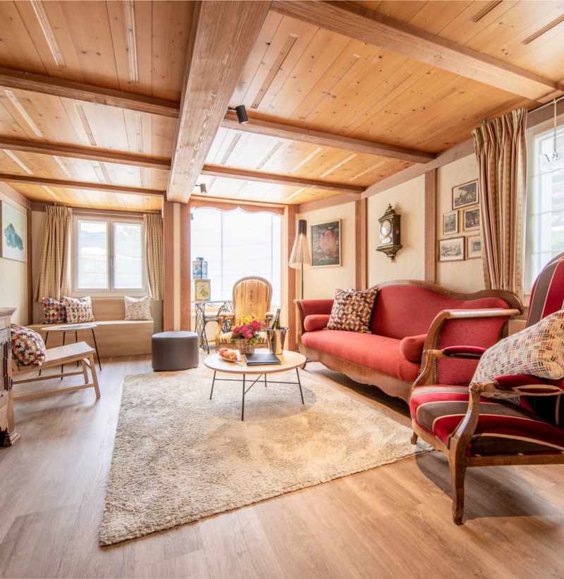 Cozy, wood-paneled living room with red plush sofas and vintage decor, radiating a warm, inviting atmosphere for home design enthusiasts.