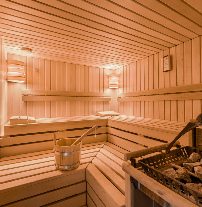 Warm-toned wooden sauna with glowing lights, creating a tranquil, relaxing atmosphere for wellness-focused spaces.