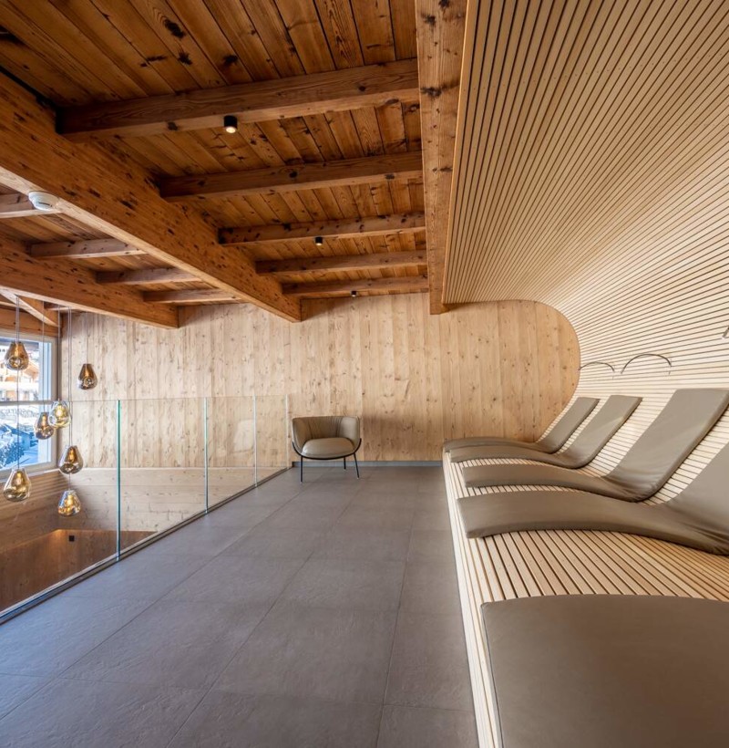 Curved wooden interiors with sleek, modern furnishings evoke a serene and refined ambiance, ideal for luxury real estate settings.