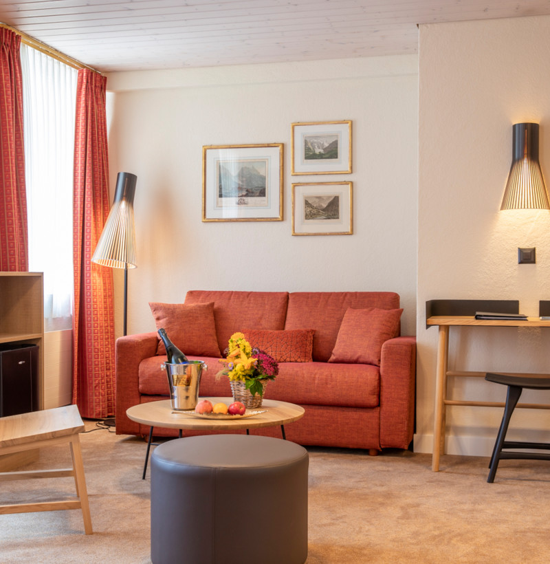 Cozy living room with a vibrant terracotta sofa set against neutral tones, creating a warm, inviting atmosphere for relaxation.