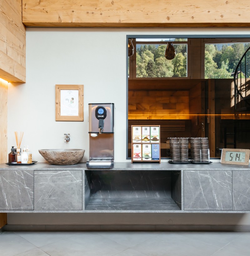 Streamlined cafe counter with grey marble and warm wooden accents, creating a serene, welcoming space for coffee lovers.