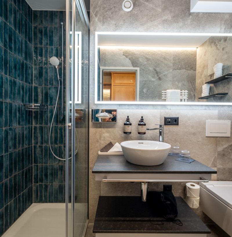 Sleek bathroom with deep blue tiles and modern fixtures, creating a serene and contemporary ambiance ideal for relaxation.