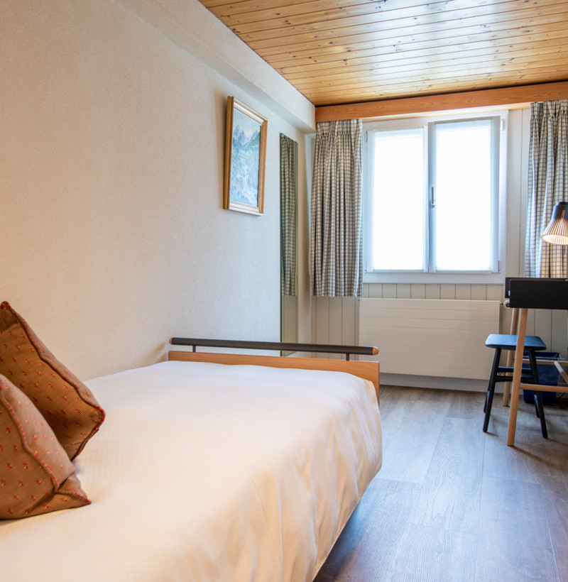 Cozy hotel room with warm neutral colors and wooden accents, evoking a homey and welcoming atmosphere for travelers.