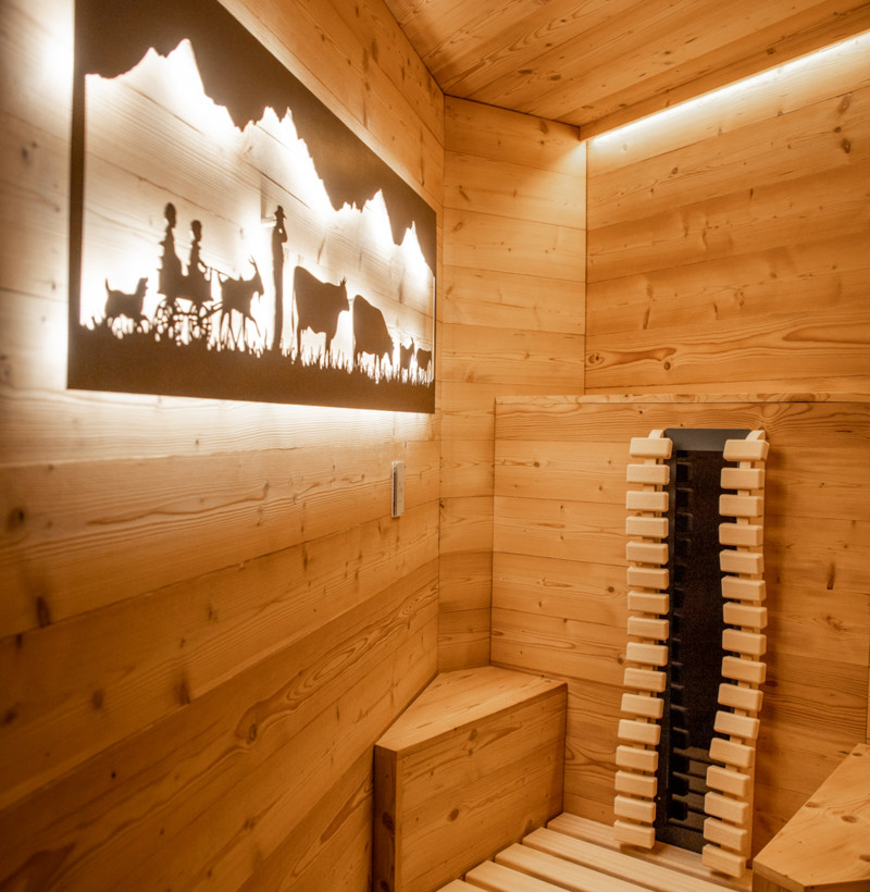 Warm wooden sauna with rustic backlight silhouettes of a pastoral scene, exuding tranquility for wellness enthusiasts.