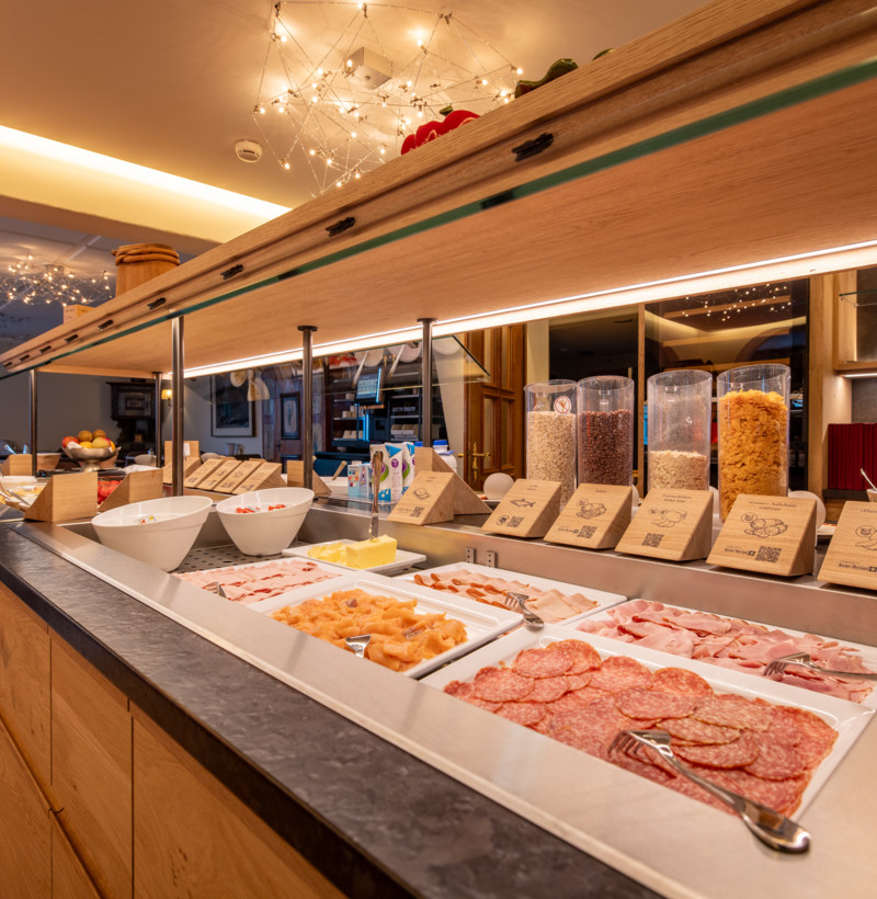 Cozy breakfast buffet setup with warm lighting and an array of fresh foods, inviting hospitality and culinary exploration.