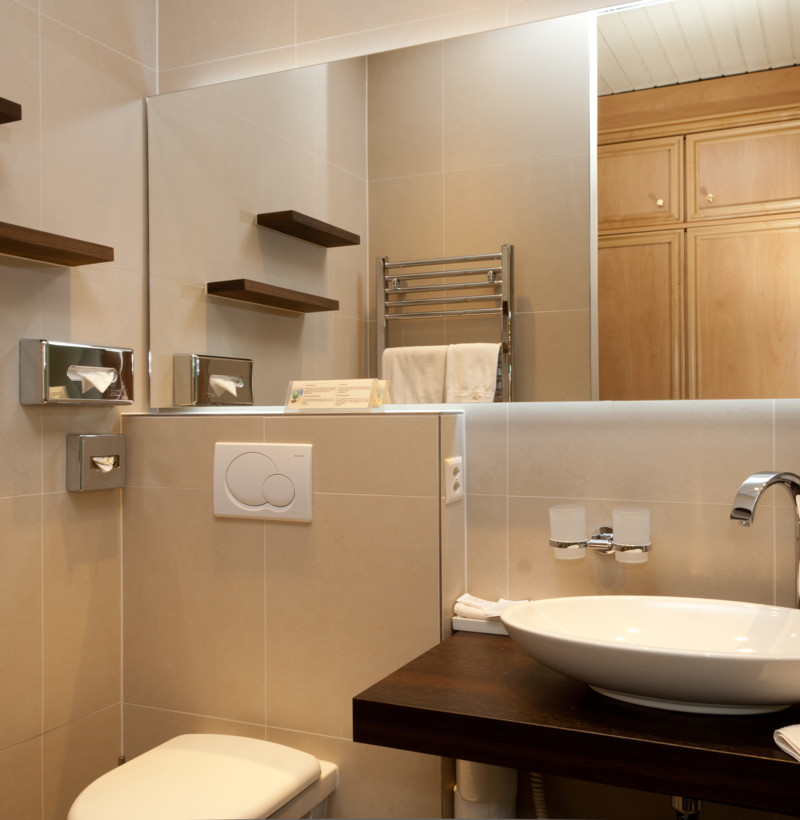 Softly lit beige bathroom with wooden accents, creating a warm and serene atmosphere for the interior design industry.