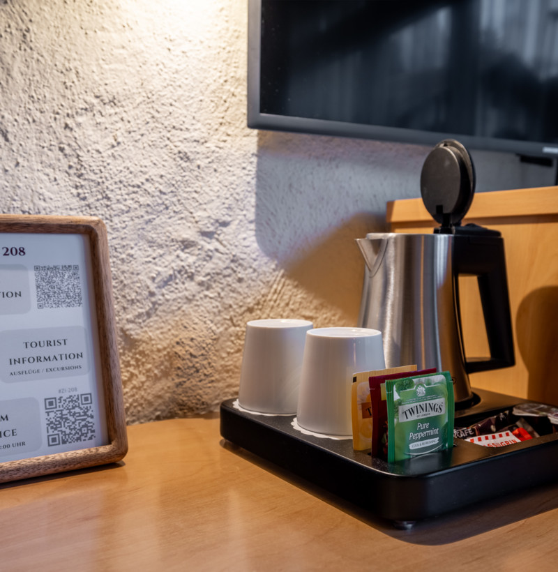 Cozy hotel hospitality corner with a wooden information frame and tea service setup, inviting and tailored for traveler convenience.