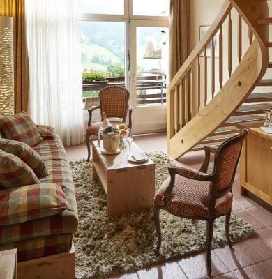 Cozy alpine-style living room with plaid sofa and wooden accents, exuding warmth and comfort, ideal for lodge or resort settings.