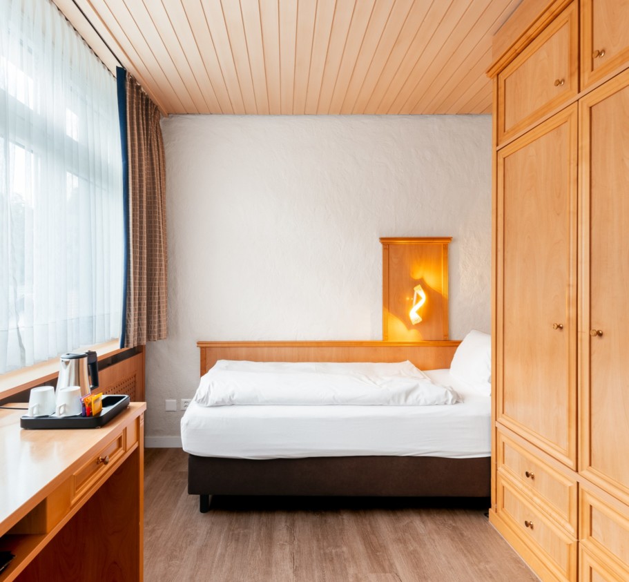 Cozy bedroom with warm wood accents and soft natural light, creating a serene ambiance ideal for rest and relaxation.